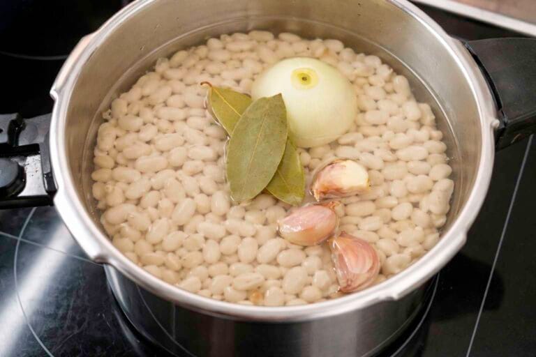Alubias blancas escurridas y listas para cocer en un recipiente de cocina