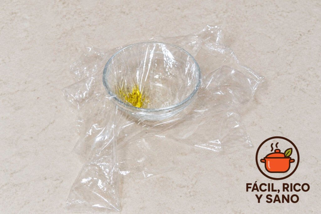 Cuenco de cristal forrado con film transparente y un poco de aceite de oliva en el fondo