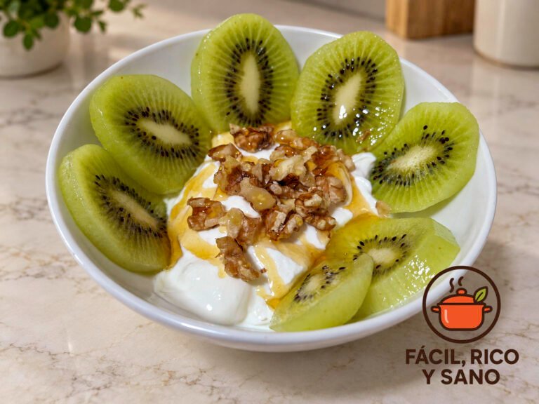 Cuenco de yogur griego con rodajas de kiwi alrededor, nueces picadas y un hilo de miel