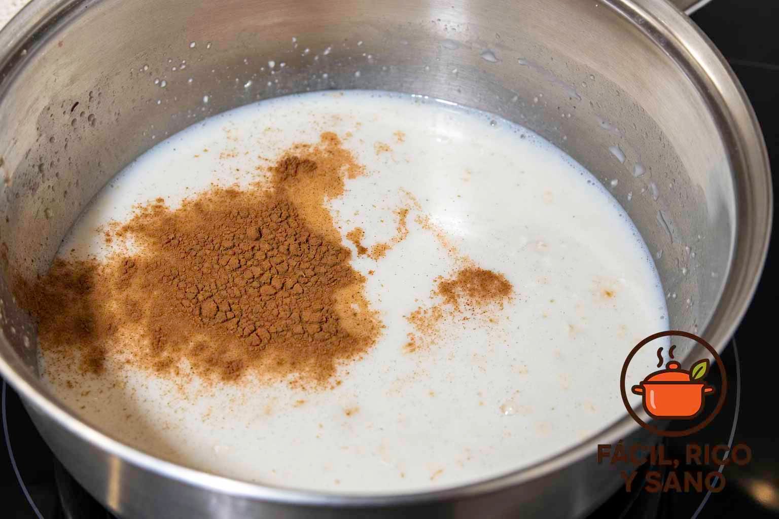 Canela en polvo sobre la avena cociéndose en un cazo