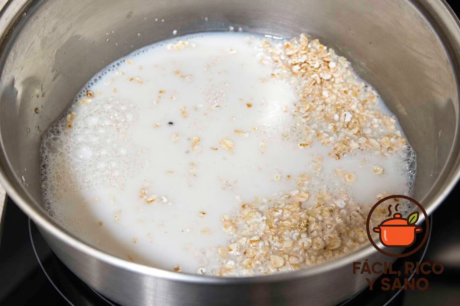 Copos de avena y bebida de almendra en un cazo sobre la vitrocerámica
