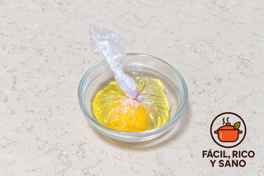 Huevo crudo envuelto en film transparente y atado con hilo, dentro de un cuenco de cristal
