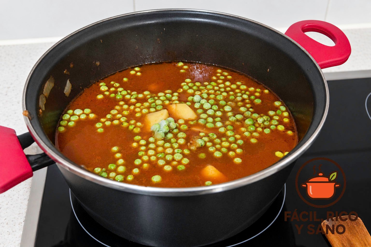 Estofado de ternera cociéndose con patatas y guisantes en la cazuela