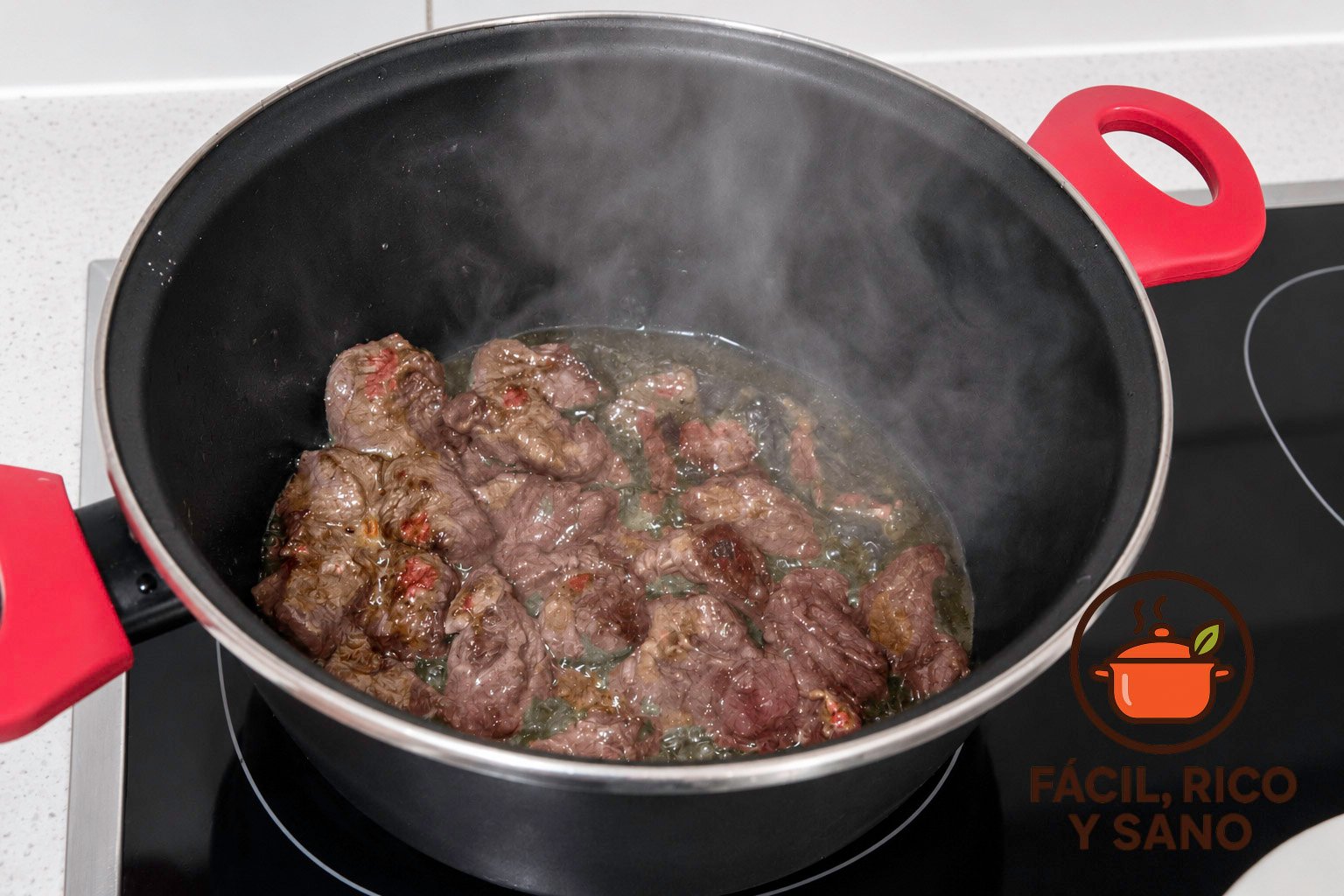 Tacos de ternera dorándose en aceite de oliva en una cazuela