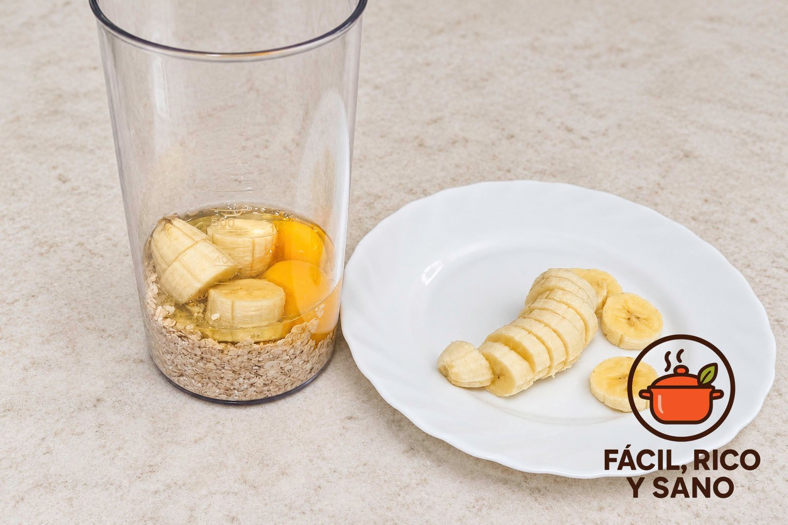 Copos de avena, dos huevos y medio plátano en el vaso de la batidora, con la otra mitad del plátano cortada en un plato