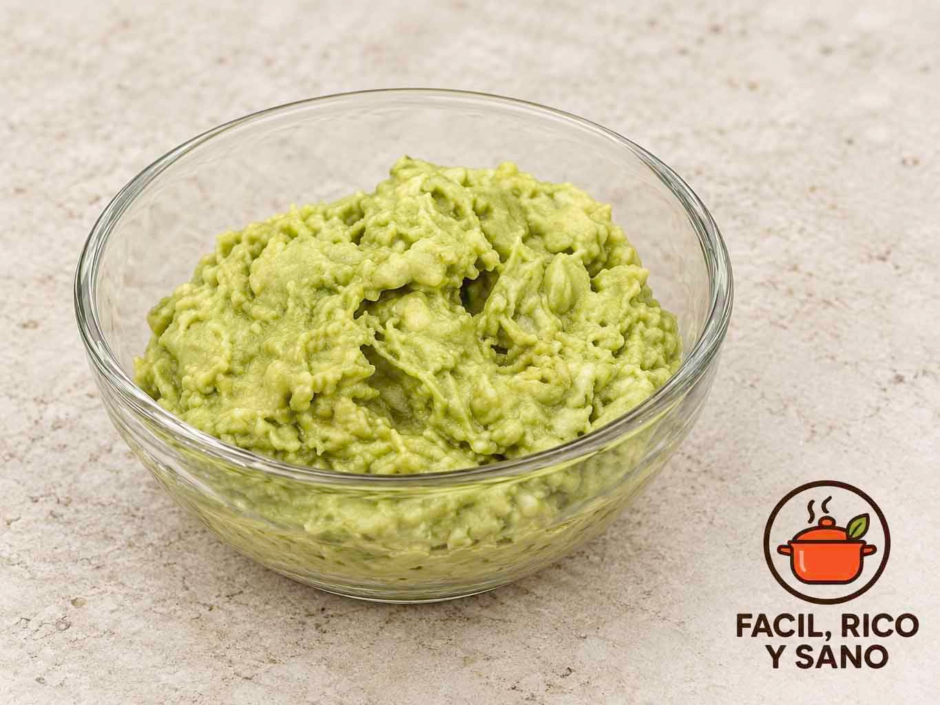 Salsa de aguacate machacado con pistachos y lima en un cuenco de cristal