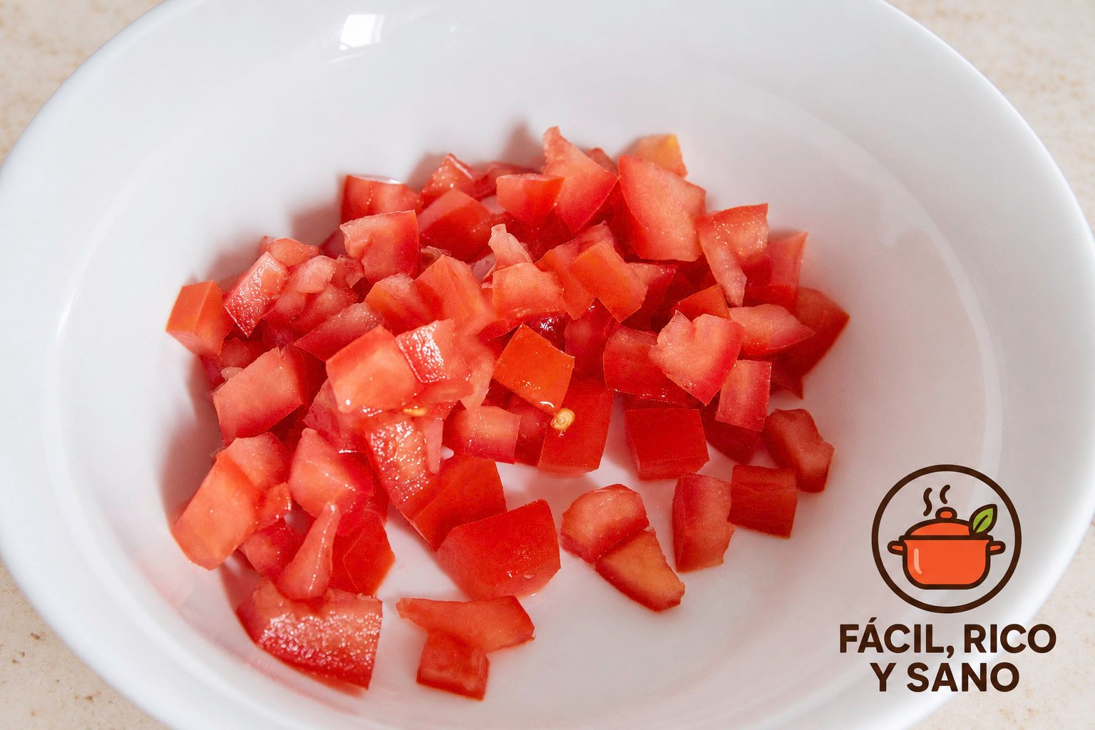 Tomate sin semillas cortado en daditos en un cuenco blanco