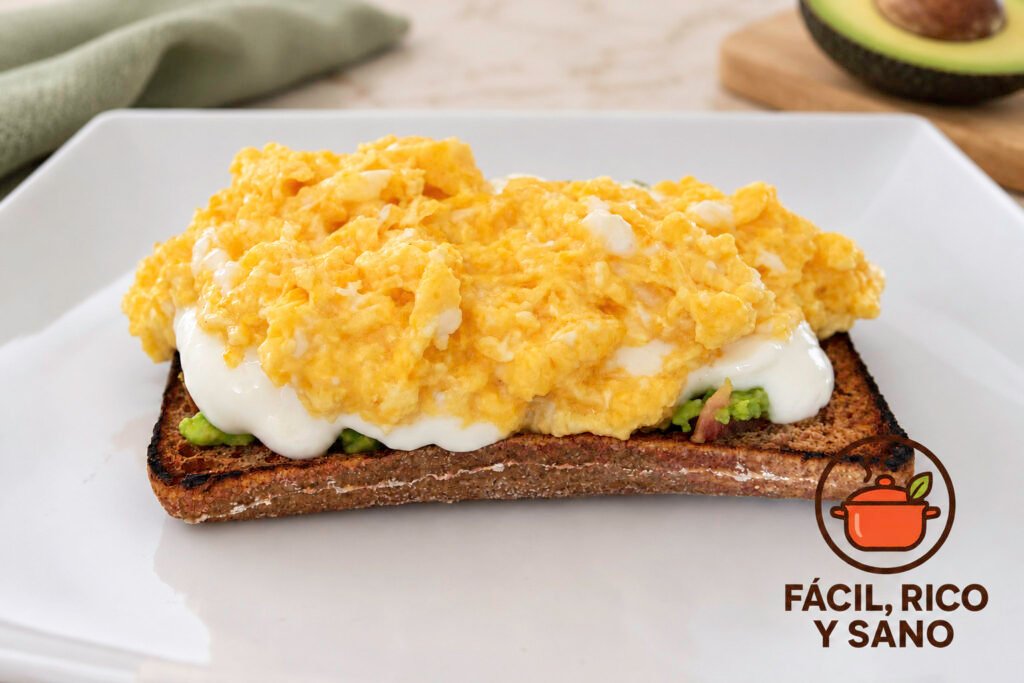 Tostada de pan integral con aguacate, queso fresco batido y huevo revuelto